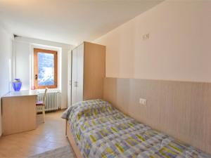 1 dormitorio con 1 cama, armario y escritorio en Apartment Casa del Bitto by Interhome en Pedesina