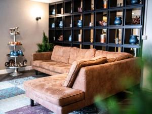 a living room with a couch and a shelf of vases at Apartment Gästehaus Grönebach mit Pool-3 by Interhome in Winterberg