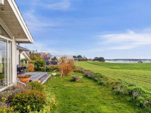 a yard with a view of a field and a house at Holiday Home Elja - 400m to the inlet in Sealand by Interhome in Jægerspris