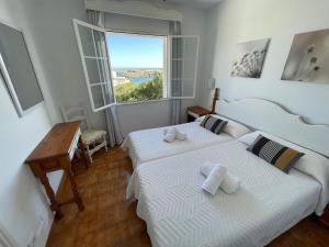 a bedroom with two beds and a desk and a window at Apartamento 204 Castell Sol CB in Arenal d'en Castell
