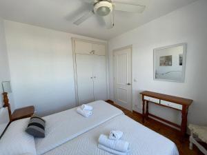 a bedroom with two beds with towels on them at Apartamento 204 Castell Sol CB in Arenal d'en Castell