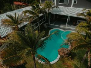 Una vista aérea de una piscina con palmeras. en CHICO DINA POUSADA, en Amontada