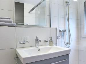 a white bathroom with a sink and a shower at Apartment Ibex by Interhome in Kandersteg