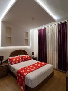ein Schlafzimmer mit einem Bett mit roten Kissen in der Unterkunft Appartement pour famille à Agadir 10 minutes de la plage Parking gratuit in Agadir