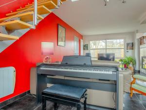 een kamer met een piano en een rode muur bij Holiday Home Villa Rucette by Interhome in La Richardais