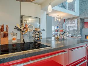 a kitchen with a black counter top and red cabinets at Holiday Home Villa Rucette by Interhome in La Richardais
