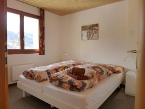 a bedroom with a bed with a comforter on it at Apartment Chalet Gredetsch by Interhome in Bürchen