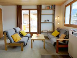 a living room with two couches and a table at Apartment Chalet Gredetsch by Interhome in Bürchen