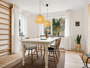 uma sala de jantar com uma mesa branca e cadeiras em Holiday Home Birtir - 750m from the sea in NW Jutland by Interhome em Hanstholm