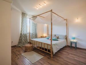 een slaapkamer met een hemelbed en een houten vloer bij Apartment La casa dei limoni di Valeria by Interhome in Torre del Lago Puccini