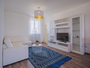 Una sala de estar con un sofá blanco y un televisor. en Apartment La casa dei limoni di Valeria by Interhome, en Torre del Lago Puccini