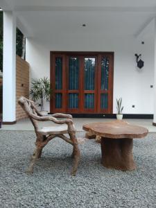un banco de madera y una mesa frente a un edificio en Oqura Villa, en Ahangama