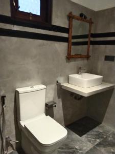 y baño con aseo blanco y lavamanos. en Oqura Villa, en Ahangama