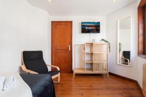 a bedroom with a bed and a chair and a door at Host Wise - Charming Spacious Duplex House in Infesta