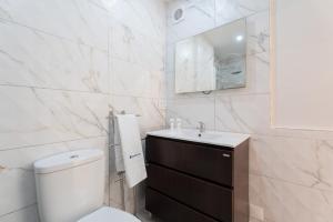 bagno con servizi igienici, lavandino e specchio di Host Wise - Charming Spacious Duplex House a Infesta