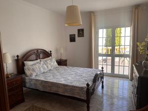Un dormitorio con una cama y una puerta a un patio. en Dream House Near the Beach, en Porches 8 fotos más
