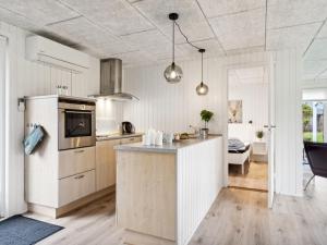 eine Küche mit weißen Schränken und einer Arbeitsplatte in der Unterkunft Holiday Home Marielouise - from the sea in NE Jutland by Interhome in Hals