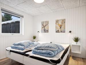 1 Schlafzimmer mit 2 Betten und blauen Kissen in der Unterkunft Holiday Home Marielouise - from the sea in NE Jutland by Interhome in Hals