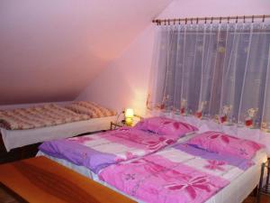two beds in a room with pink sheets and a window at Holiday Home Smrž by Interhome in Dudov