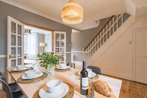 - une salle à manger avec une table et une bouteille de vin dans l'établissement Heritage Cottage - Charming and stylish home with lovely garden, à Walmer