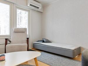 Cette chambre comprend un lit et une chaise. dans l'établissement Holiday Home Ylä-luosta by Interhome, à Rautavaara