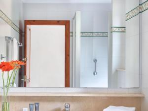 a bathroom with a large mirror over a sink at Apartment Hapimag-4 by Interhome in Platja  d'Aro