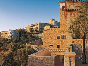a brick building with a tower and buildings in the background at Apartment Hapimag-4 by Interhome in Platja  d'Aro