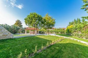 a garden with a gazebo and a lawn at Pelagus Luxury Villas in Polykhrono