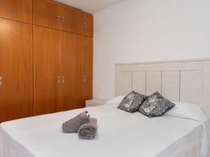 a white bed with two pillows and a stuffed animal on it at Apartment El apartamento de Noa by Interhome in Rincón de la Victoria