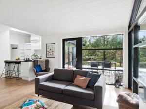 ein Wohnzimmer mit einem Sofa und einer Küche in der Unterkunft Holiday Home Ela - 800m from the sea in Sealand by Interhome in Vig