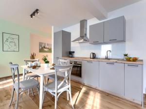 a kitchen with white cabinets and a table and chairs at Studio Zanet by Interhome in Fažana