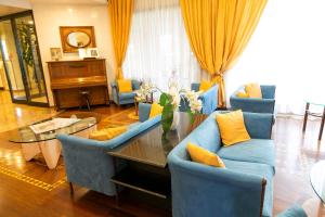 a living room with blue chairs and a glass table at Melas Hotel in Merate