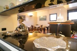 Uma estátua de um homem sentado numa mesa numa vitrine. em Melas Hotel em Merate