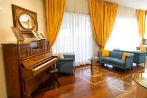 een woonkamer met een piano en een bank bij Melas Hotel in Merate