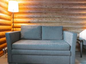 Sofá azul en una habitación con pared de madera en Holiday Home Rustholli 9 by Interhome en Tampere