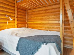 a bedroom with a bed in a wooden cabin at Holiday Home Rustholli 9 by Interhome in Tampere