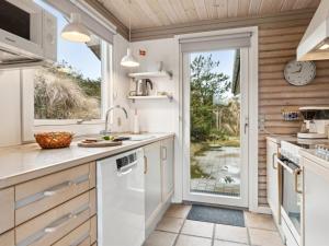 een keuken met witte apparatuur en een raam bij Holiday Home Selenia - 1km from the sea in NW Jutland by Interhome in Saltum