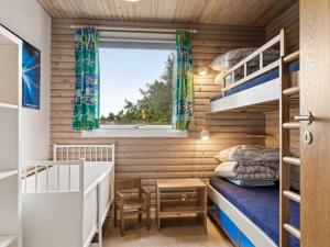 niewielka sypialnia z łóżkiem piętrowym i oknem w obiekcie Holiday Home Selenia - 1km from the sea in NW Jutland by Interhome w mieście Saltum