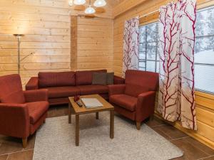 uma sala de estar com um sofá e duas cadeiras e uma mesa em Holiday Home Hankirati 8a by Interhome em Ruka