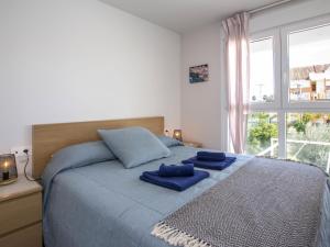 a bedroom with a bed with blue pillows on it at Apartment Victoria Playa III Plus by Interhome in Denia