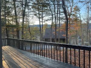 a wooden deck with a house in the woods at Black Bear Lodge in Basye