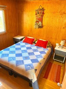 Un dormitorio con una cama con almohadas rojas. en Cabañas Pudá, en Dichato