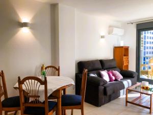 ein Wohnzimmer mit einem Sofa und einem Tisch in der Unterkunft Apartment Tamarindo-5 by Interhome in Cala de Finestrat