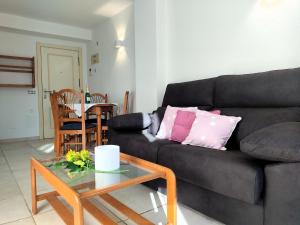 ein Wohnzimmer mit einem schwarzen Sofa und einem Tisch in der Unterkunft Apartment Tamarindo-5 by Interhome in Cala de Finestrat