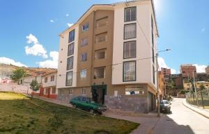 a building with a green car parked in front of it at Fiflos Apartament in Cusco