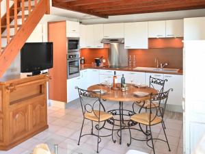 una cucina con tavolo in legno, sedie e TV di Holiday Home Green Village-4 by Interhome a Roquebrune-sur Argens