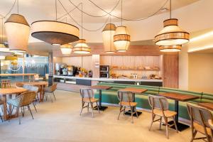 a restaurant with tables and chairs and a bar at B&B HOTEL Olhão Algarve in Olhão