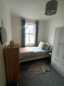 Schlafzimmer mit einem Bett und einem Fenster in der Unterkunft Birdhill Farmhouse in Tipperary