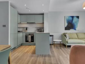 a kitchen and a living room with a couch at Apartment Wembley Park apartments-2 by Interhome in London