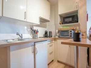 une petite cuisine avec un évier et un micro-ondes dans l'établissement Studio Port Arcachon-7 by Interhome, à Arcachon 15 autres photos